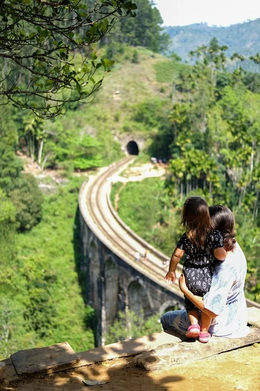 Młoda kobieta z córką patrzą na dziewięci łukowy most na Sri Lance