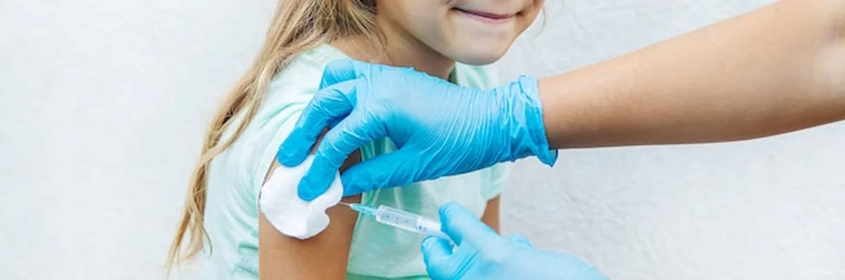 Lekarz daje dziecku zastrzyk w ramię