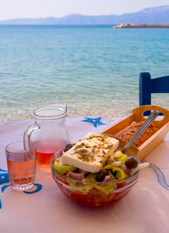 Sałatka grecka z serem feta i winem różanym na stole w Grecji