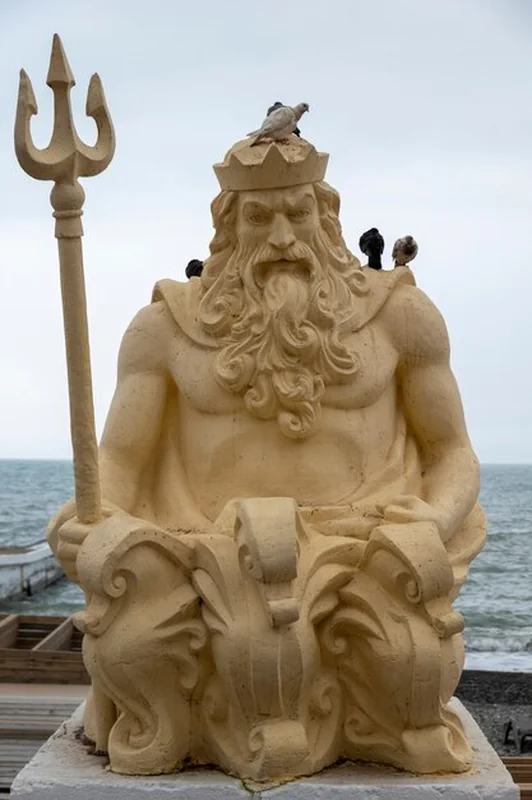 Statua Neptuna z trójzębem nad brzegiem morza