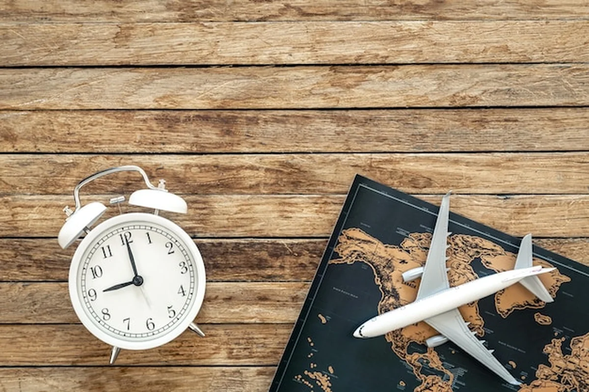 Mapa samolotu i budzik na drewnianym tle