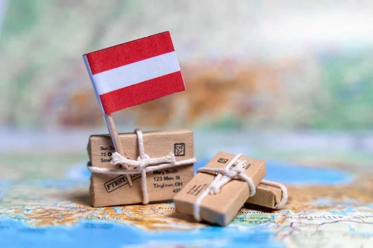 Flaga Austrii na mapie świata obok paczek
