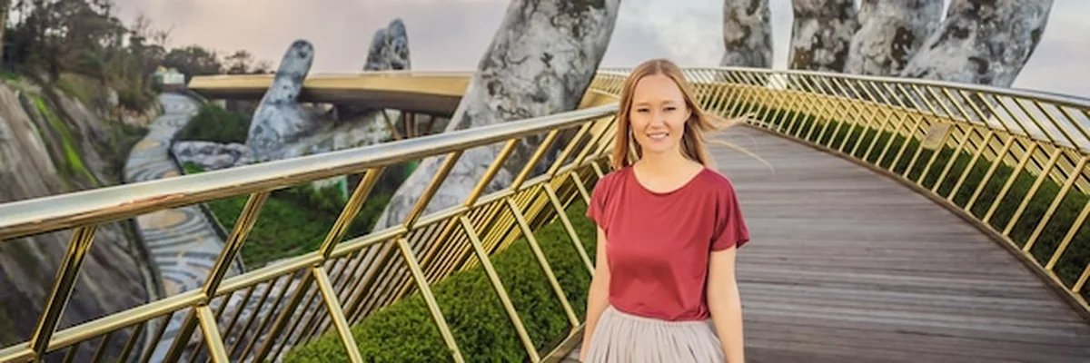 Młoda turystka na Złotym moście w Wietnamie na wzgórzach Ba Na