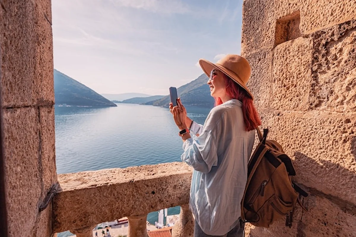 Turysta robi zdjęcia zatoki Kotor ze starych murów twierdzy