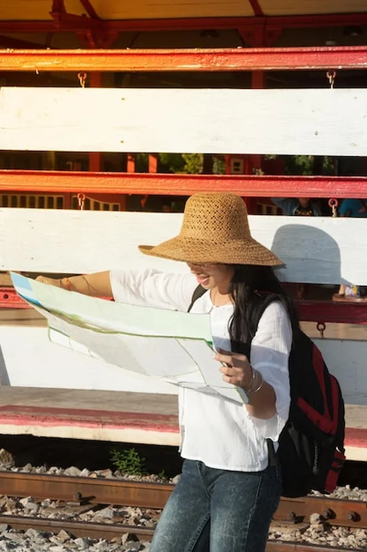 Kobieta patrząca na mapę na dworcu kolejowym