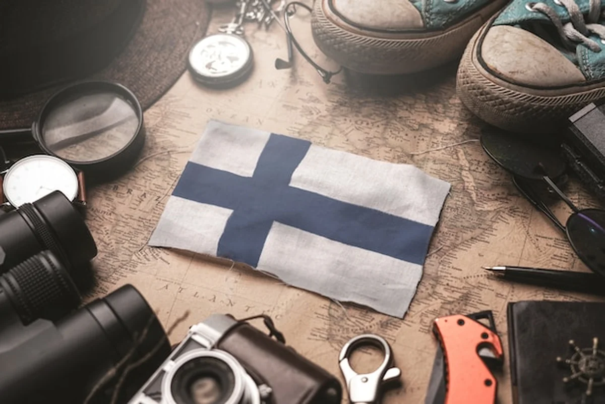Flaga Finlandii na starej mapie z akcesoriami podróżnika