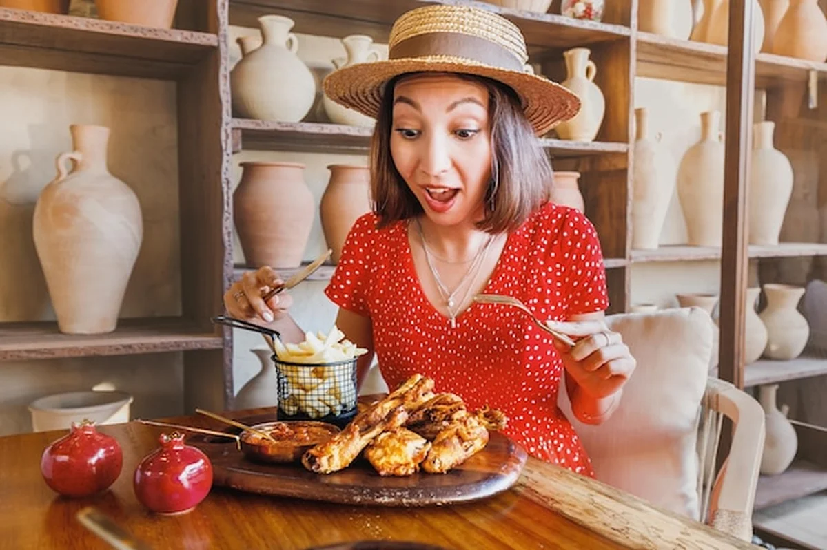 Kobieta je grillowane kurczaki z sosem w restauracji wiejskiej