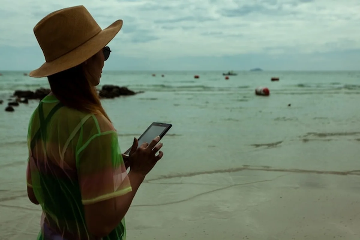 Kobieta używająca telefonu komórkowego na plaży