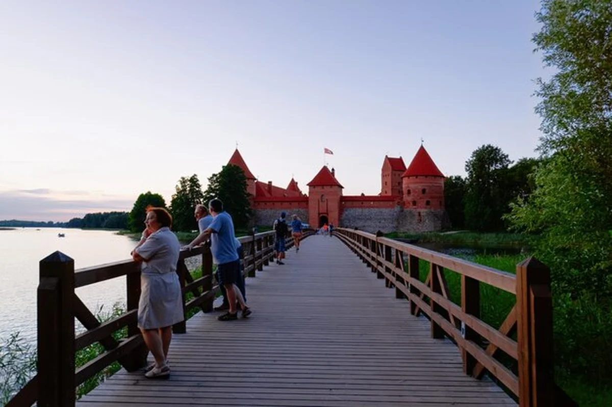 Ludzie na zamku w Trokach nad jeziorem Galve w Trokach Litwy wieczorem