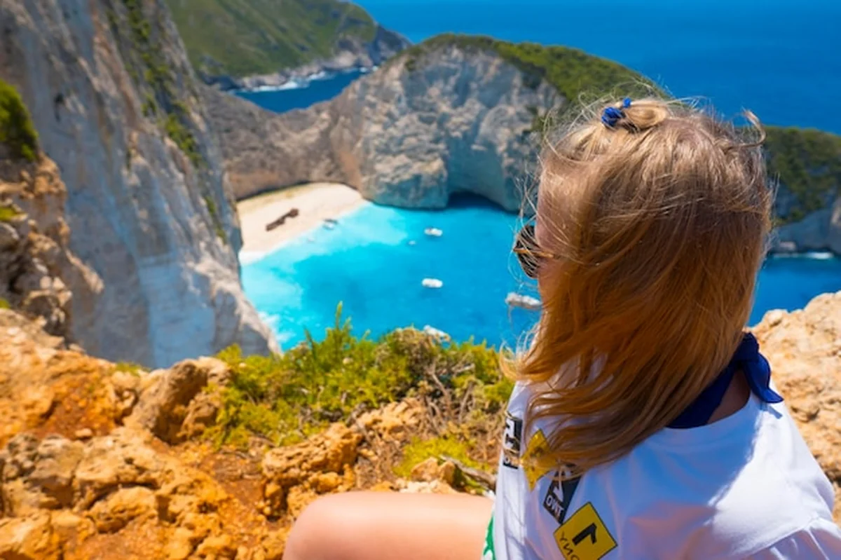 Dziewczyna podziwiająca plażę Navagio na Zakynthos z góry