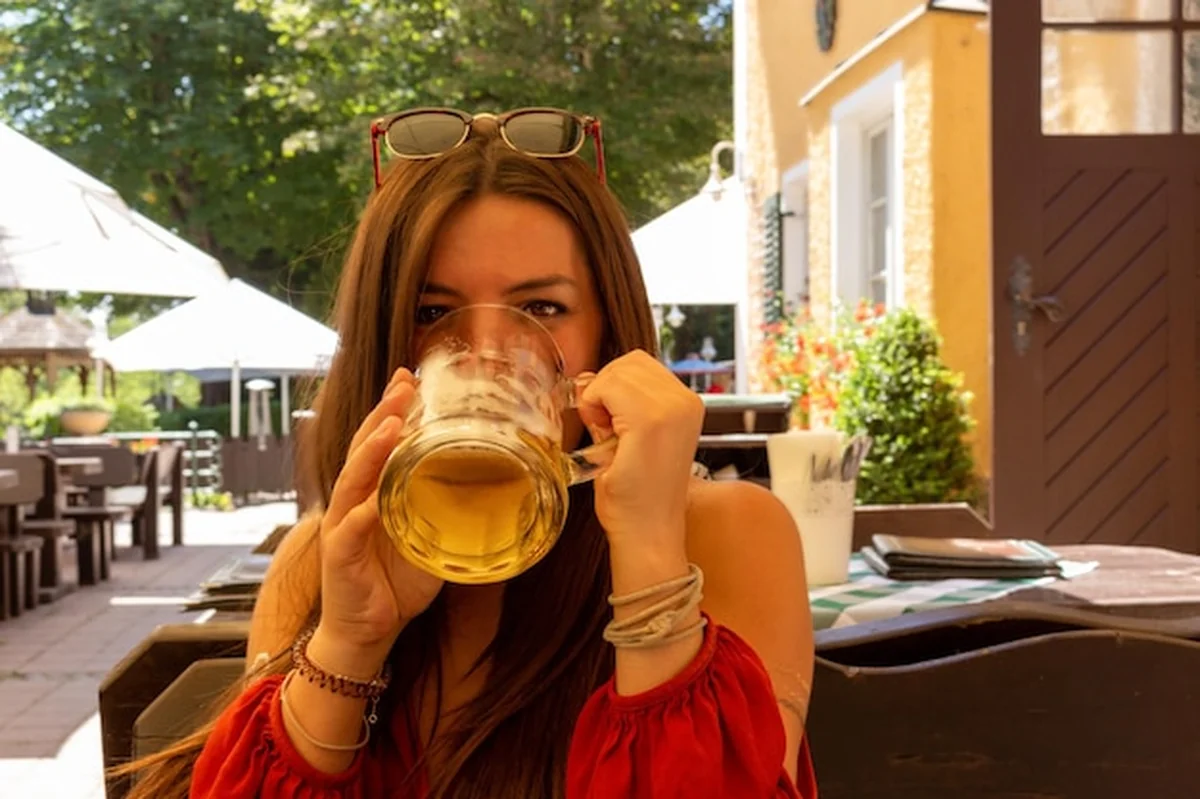 Młoda kobieta pije piwo w piwnicy