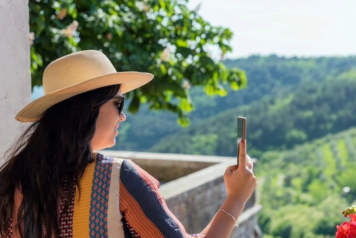 Kobieta robi zdjęcia pięknego krajobrazu z tarasu starego budynku