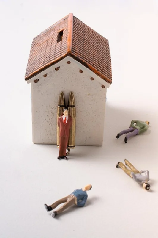 Model figurki mężczyzny i kula na tle fotografii wojennej