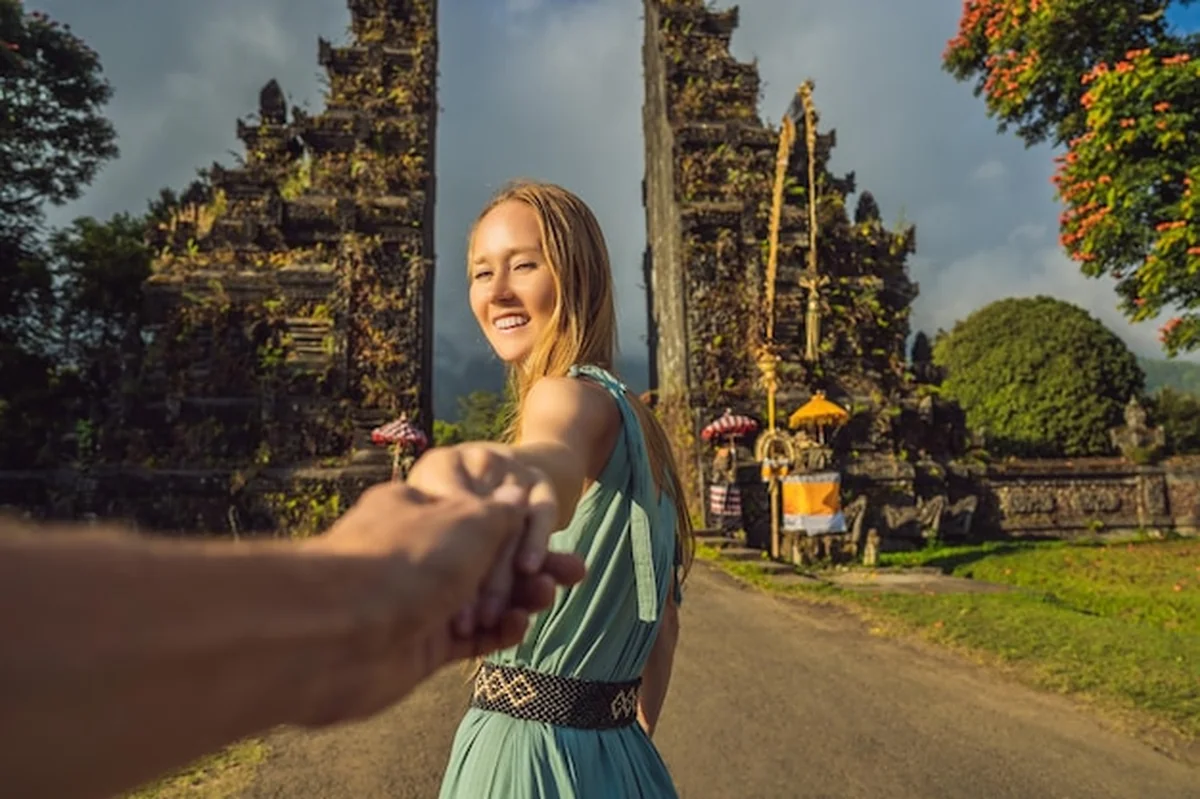 Turystyczna kobieta przechodząca przez tradycyjną balijską bramę